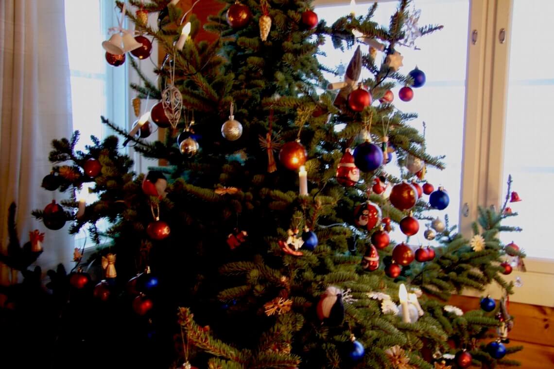 Christmas tree is decorated with old decorations from the family's history. Decades are different and so is this spruce. Guess why!