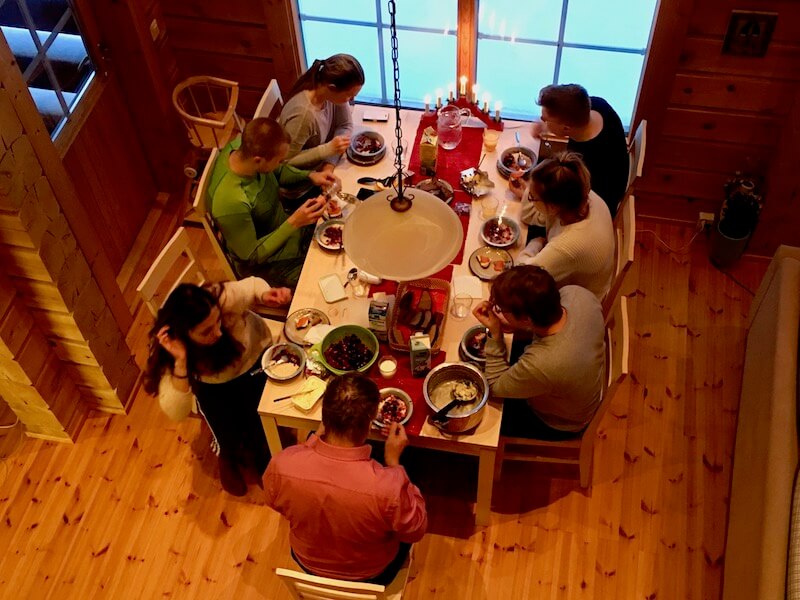 Family having a Christmas Eve dinner at Syöte in a log cabin.